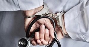 Harsher penalties for medical aid fraud called for Female Doctor or Nurse In Handcuffs and Lab Coat Holding Stethoscope.